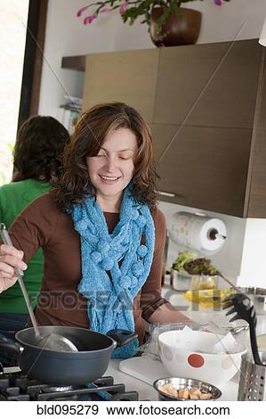 Stock Photo - Hispanic family cooking in kitchen. Fotosearch