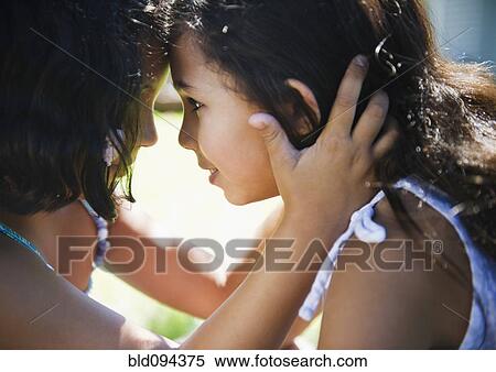 Stock Photography - Hispanic girl comforting her sister. Fotosearch
