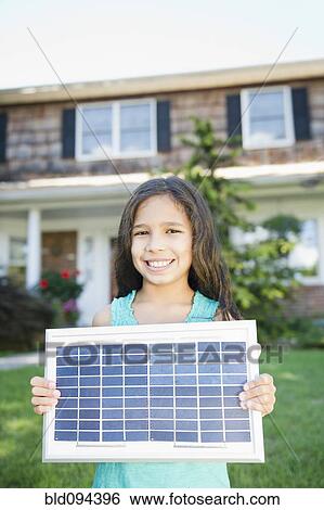 Stock Photograph - Hispanic girl holding solar panel. Fotosearch