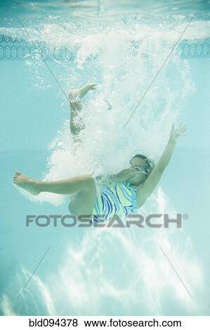 Stock Photo - Hispanic girl jumping into swimming pool. Fotosearch