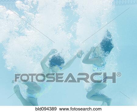 Stock Photo - Hispanic girls jumping into swimming pool. Fotosearch