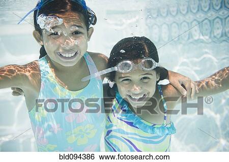 Hispanic girls swimming under water View Large Photo Image Stock Photograph - Hispanic girls swimming under water. Fotosearch