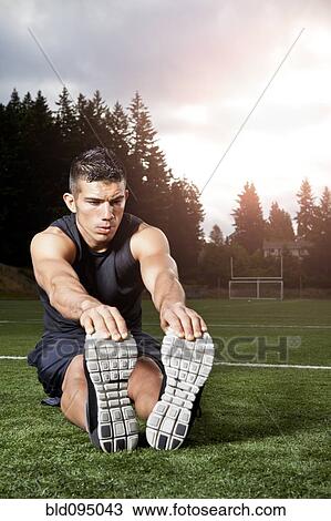 Stock Image - Hispanic man stretching before exercise. Fotosearch
