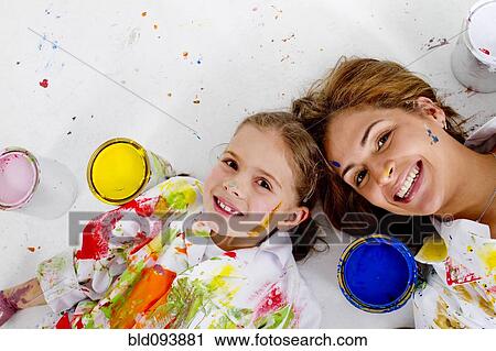 Hispanic mother and daughter covered in paint laying on floor View Large Photo Image Stock Image - Hispanic mother and daughter covered in paint laying on floor. Fotosearch