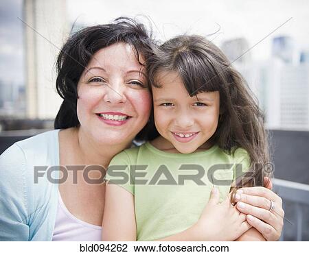 Stock Image - Hispanic mother and daughter hugging. Fotosearch