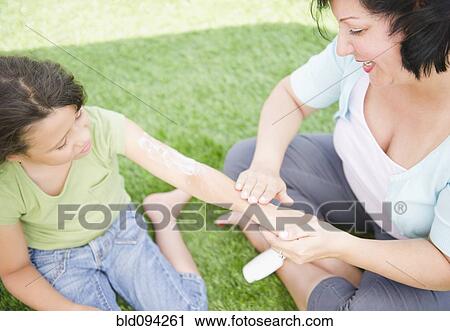 Hispanic mother putting sunscreen on daughter View Large Photo Image Stock Image - Hispanic mother putting sunscreen on daughter. Fotosearch