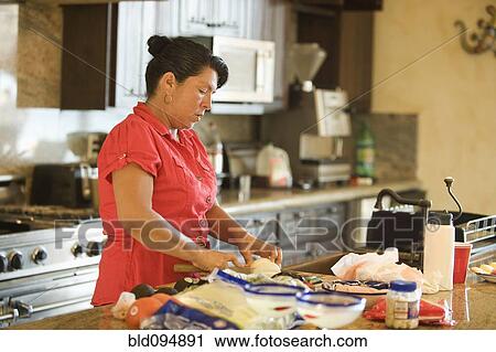 Hispanic woman cooking in kitchen View Large Photo Image Stock Image - Hispanic woman cooking in kitchen. Fotosearch