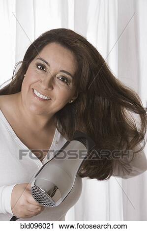 Hispanic woman drying her hair View Large Photo Image Stock Image - Hispanic woman drying her hair. Fotosearch