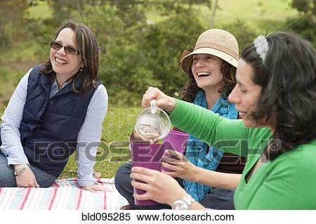 Stock Photography - Hispanic woman enjoying picnic. Fotosearch