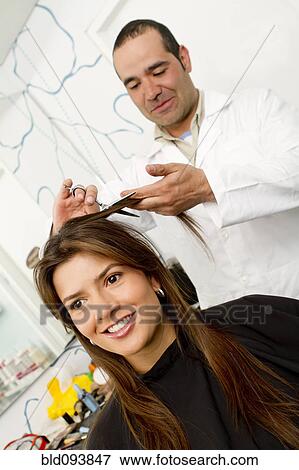 Stock Photo - Hispanic woman having her hair cut in salon. Fotosearch