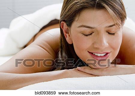 Stock Photo - Hispanic woman laying on massage table. Fotosearch