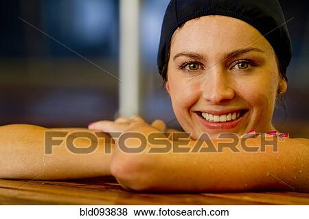Stock Photo - Hispanic woman leaning on edge of swimming pool. Fotosearch