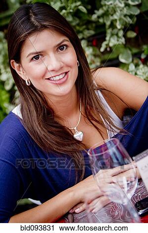 Stock Image - Hispanic woman sitting outdoors. Fotosearch