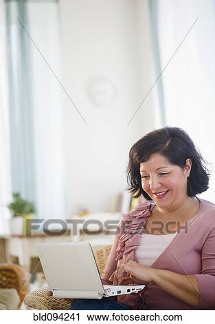Stock Image - Hispanic woman using laptop. Fotosearch