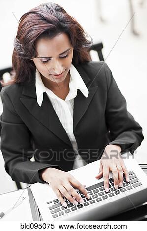 Stock Photography - Indian businesswoman typing on laptop. Fotosearch