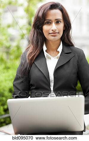 Indian businesswoman using laptop outdoors View Large Photo Image Stock Image - Indian businesswoman using laptop outdoors. Fotosearch