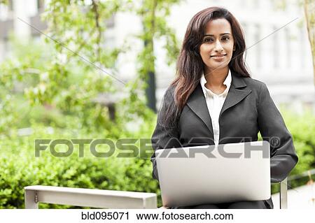 Indian businesswoman using laptop outdoors View Large Photo Image Stock Image - Indian businesswoman using laptop outdoors. Fotosearch