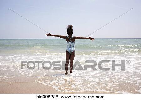 Stock Photo - Jamaican girl wading on beach. Fotosearch