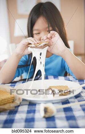 Picture - Korean girl eating smores. Fotosearch