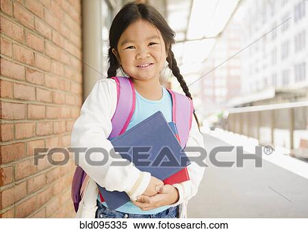 Korean girl holding books on sidewalk View Large Photo Image Stock Photography - Korean girl holding books on sidewalk. Fotosearch