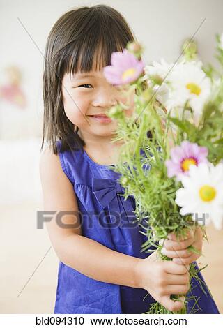 Stock Image - Korean girl holding bouquet of flowers. Fotosearch