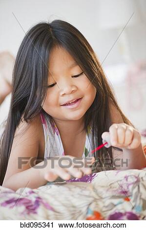Korean girl putting on fingernail polish View Large Photo Image Stock Image - Korean girl putting on fingernail polish. Fotosearch