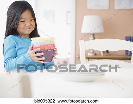 Stock Image - Korean girl setting the table. Fotosearch