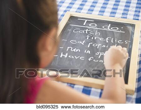 Stock Photography - Korean girl writing to do list on blackboard. Fotosearch