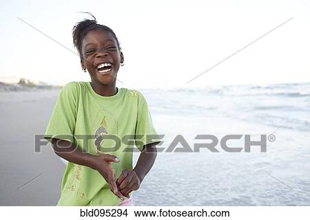 Picture - Laughing Jamaican girl on beach. Fotosearch