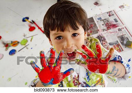 Stock Image - Messy Hispanic boy finger painting. Fotosearch