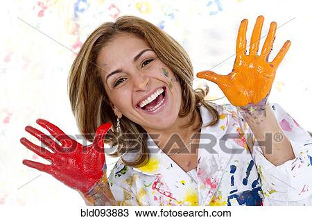 Stock Image - Messy Hispanic woman finger painting. Fotosearch