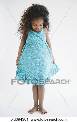 Mixed race girl admiring her dress View Large Photo Image Stock Image - Mixed race girl admiring her dress. Fotosearch