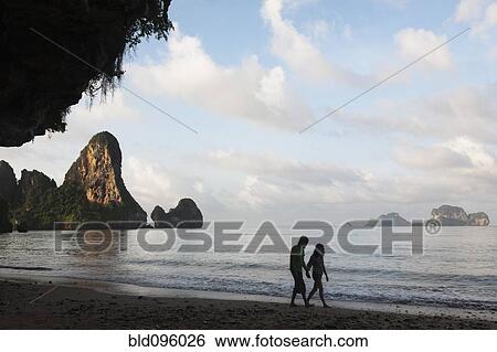 Stock Photograph - People walking on Thai beach. Fotosearch