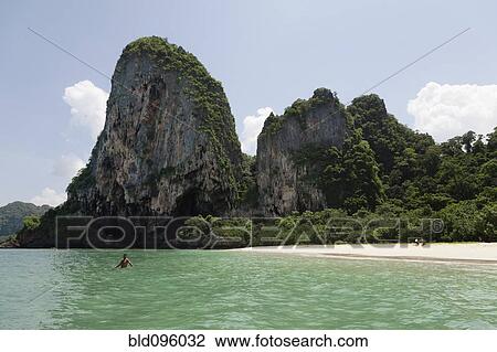 Stock Image - Person wading on ocean near beach. Fotosearch