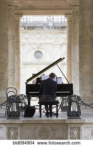 Picture - Pianist playing piano outdoors. Fotosearch