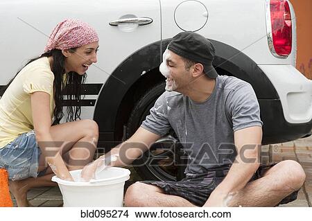 Playful Hispanic couple washing car together View Large Photo Image Picture - Playful Hispanic couple washing car together. Fotosearch