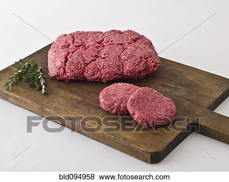 Stock Photo - Raw hamburger meat on cutting board. Fotosearch