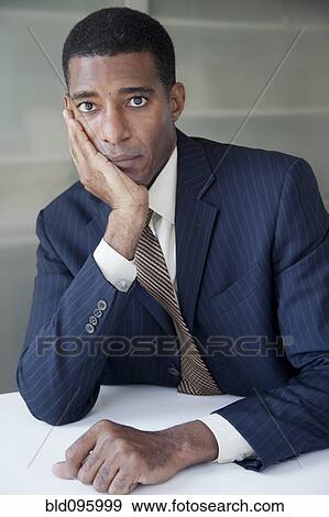 Serious Black businessman with head in hands View Large Photo Image Stock Photo - Serious Black businessman with head in hands. Fotosearch