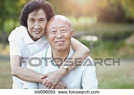 Stock Photography - Smiling senior Chinese couple hugging. Fotosearch