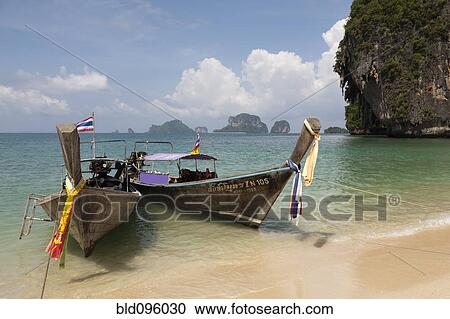 Stock Image - Thai long tail boats on beach. Fotosearch