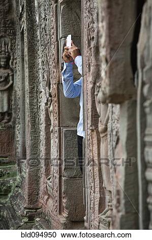 Tourist photographing Ta Prohm temple View Large Photo Image Stock Image - Tourist photographing Ta Prohm temple. Fotosearch