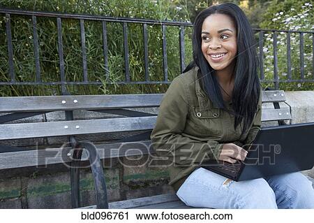 African American woman using laptop on park bench View Large Photo Image Stock Image - African American woman using laptop on park bench. Fotosearch