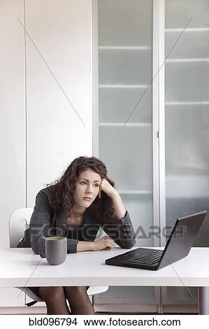 Bored businesswoman sitting at desk View Large Photo Image Picture - Bored businesswoman sitting at desk. Fotosearch