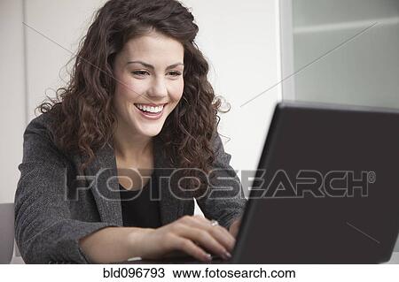 Stock Image - Businesswoman typing on laptop. Fotosearch