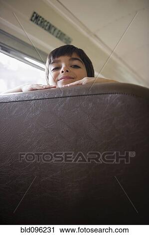 Stock Image - Caucasian boy riding school bus. Fotosearch