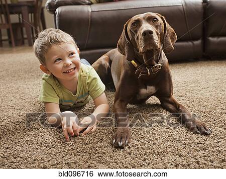 Caucasian boy sitting on floor with dog View Large Photo Image Stock Photograph - Caucasian boy sitting on floor with dog. Fotosearch