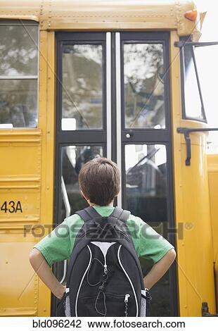 Stock Image - Caucasian boy waiting for school bus. Fotosearch