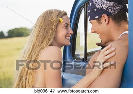 Stock Photo - Caucasian couple talking near old-fashioned truck. Fotosearch
