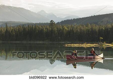 Stock Image - Caucasian mother and daughter canoeing on Lake Edith. Fotosearch