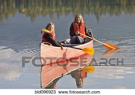Stock Image - Caucasian mother and daughter canoeing on Lake Edith. Fotosearch